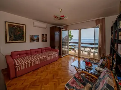 a living room with a couch and a view of the ocean at Seaview Bosco Apartment in Dobra Voda