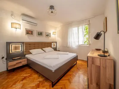 a bedroom with a large bed and a window at Seaview Bosco Apartment in Dobra Voda