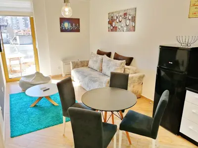 a living room with a couch and a table and chairs at Orange Lux Apartments in Budva
