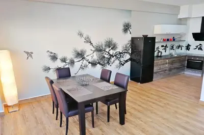 a dining room with a table and chairs and a kitchen at Orange Lux Apartments in Budva