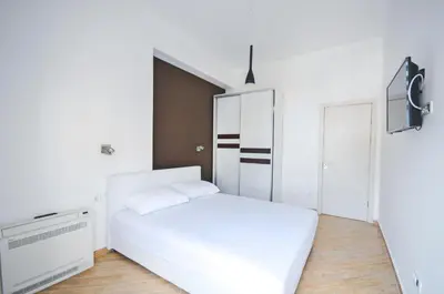 a bedroom with a white bed and a closet at Orange Lux Apartments in Budva