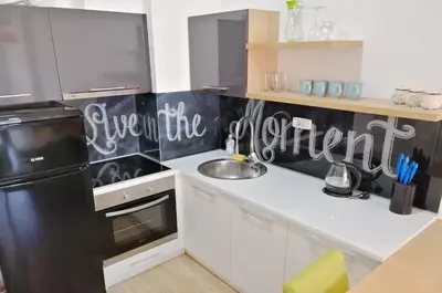 a kitchen with a sink and a black refrigerator at Orange Lux Apartments in Budva