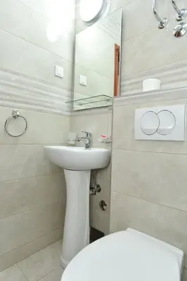 a bathroom with a sink and a toilet and a mirror at Vila IDILA in Budva