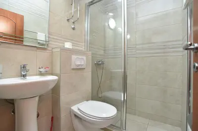 a bathroom with a toilet and a sink and a shower at Vila IDILA in Budva