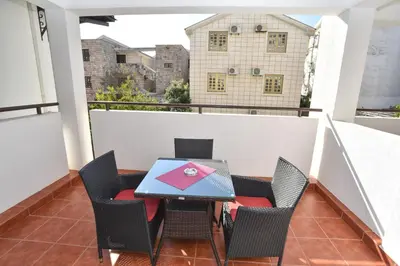 a balcony with a table and chairs on a roof at Vila IDILA in Budva