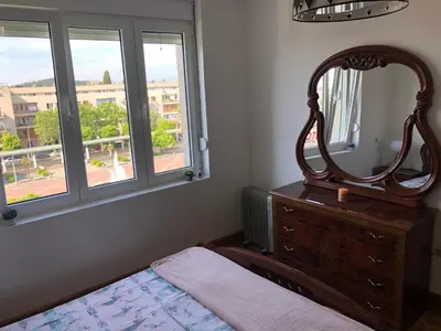a bedroom with a mirror on top of a dresser at Square apartment Podgorica in Podgorica