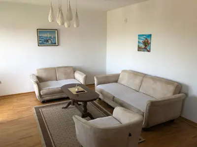 a living room with a couch and a table and chairs at Square apartment Podgorica in Podgorica