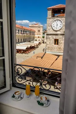 a view of a clock tower from a balcony at Apartments Hun in Kotor