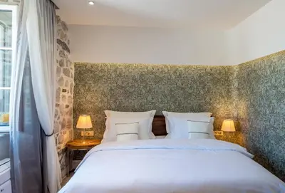 a bedroom with a large white bed and a window at Apartments Hun in Kotor