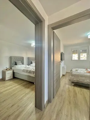 a bedroom with two beds and a mirror at Maxim Family Apartment Budva in Budva