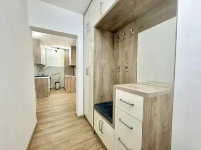 a kitchen with white cabinets and wooden floors at Maxim Family Apartment Budva in Budva