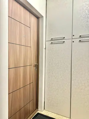 a closet with two wooden doors and a rug at Maxim Family Apartment Budva in Budva
