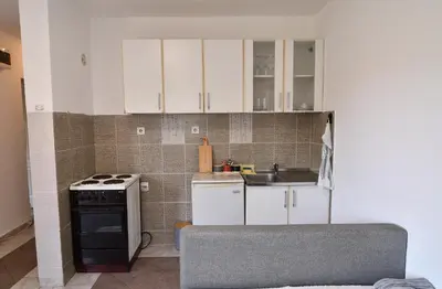 a kitchen with white cabinets and a sink and a stove at Perfect Location close to Jaz beach - Apartments Rora Knezevic in Budva