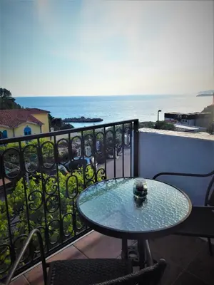 a table on a balcony with a view of the ocean at Vila Teodora in Sveti Stefan