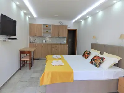 a hotel room with two beds and a kitchen at Vila Teodora in Sveti Stefan