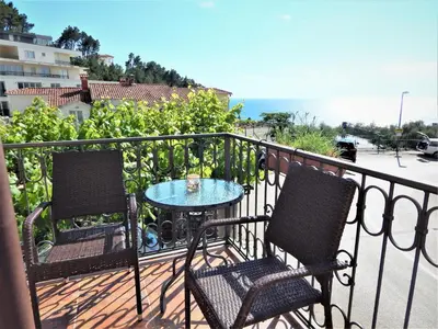 two chairs and a table on a balcony with the ocean at Vila Teodora in Sveti Stefan