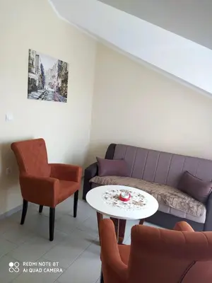 a living room with a couch and a table and chairs at Apartmani Popović V&A in Tivat