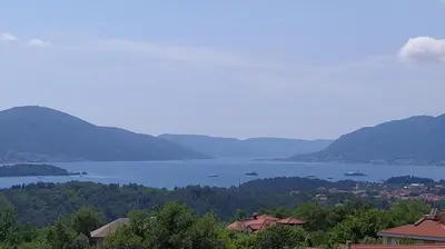 a view of a large body of water with mountains at Apartmani Popović V&A in Tivat