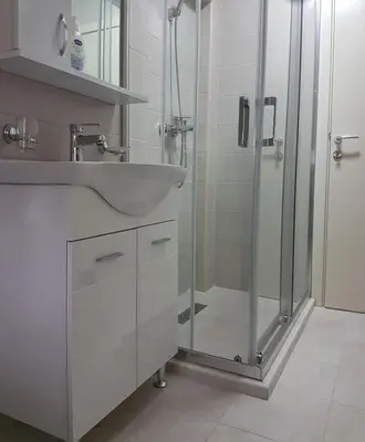 a bathroom with a sink and a shower at Apartmani Popović V&A in Tivat