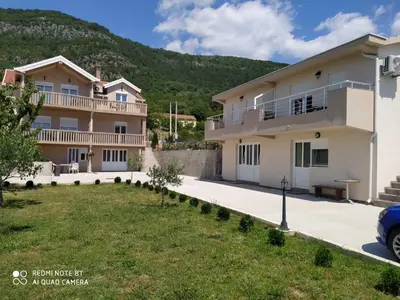 a large house with a lawn in front of it at Apartmani Popović V&A in Tivat