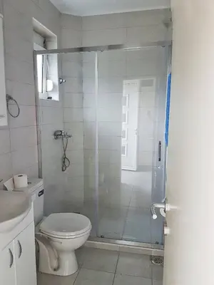 a bathroom with a glass shower with a toilet at Apartmani Popović V&A in Tivat