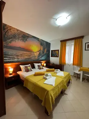 a bedroom with two beds and a painting on the wall at Apartments Krapina Lux in Budva