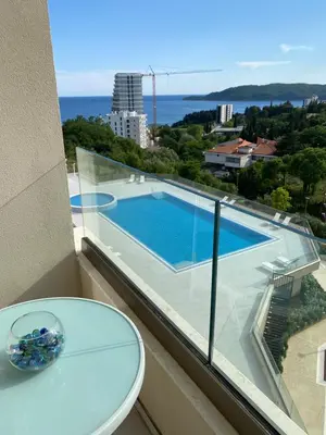 a balcony with a view of a swimming pool at Comfort studio with sea view and swimming pool in Becici