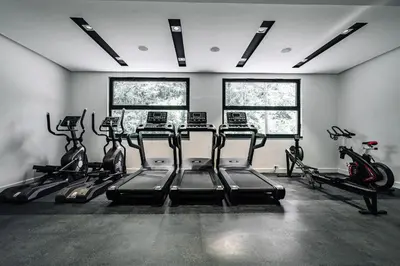 a gym with treadmills and bikes in a room at Comfort studio with sea view and swimming pool in Becici