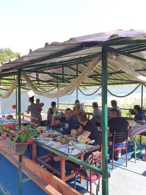 a group of people sitting at a table under a canopy at Mali Raj Apartmani in Cetinje