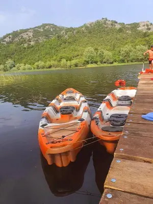 two boats tied to a dock in the water at Mali Raj Apartmani in Cetinje