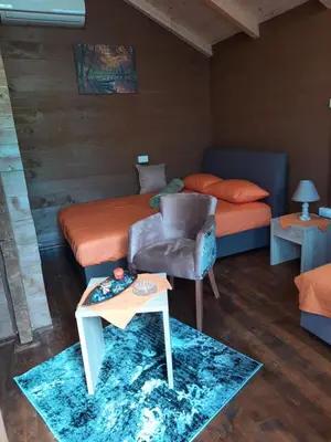 a bedroom with a bed and a chair and a table at Mali Raj Apartmani in Cetinje