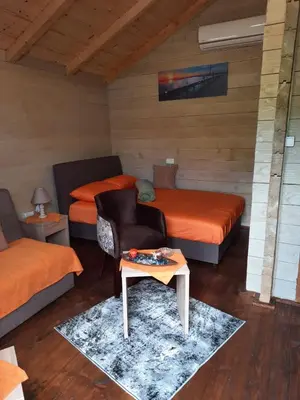 a room with two beds and a table in it at Mali Raj Apartmani in Cetinje