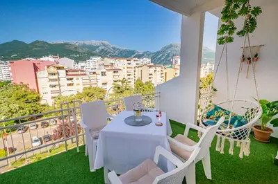 a white table and chairs on a balcony with a view at City center de Lux apartment in Bar