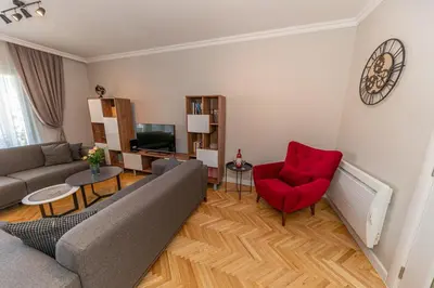 a living room with a couch and a red chair at City center de Lux apartment in Bar