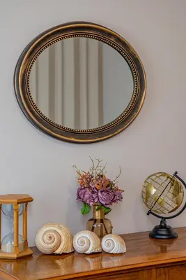 a mirror on a wall above a table with flowers at City center de Lux apartment in Bar