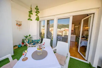 a dining room with a table and chairs and a balcony at City center de Lux apartment in Bar