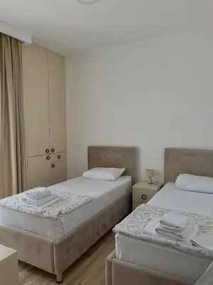 a bedroom with two beds and a cabinet at Hotel Kaligrosh in Sutomore