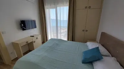 a bedroom with a bed with a blue pillow and a window at Hotel Kaligrosh in Sutomore