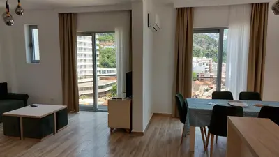 a living room with a dining room table with a view at Hotel Kaligrosh in Sutomore
