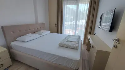 a bedroom with a white bed and a window at Hotel Kaligrosh in Sutomore
