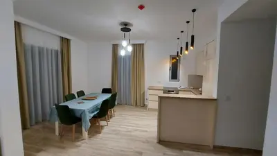 a kitchen and dining room with a table and chairs at Hotel Kaligrosh in Sutomore