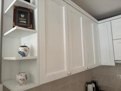 a kitchen with white cabinets and a shelf at Front Row Sunset in Rafailovici