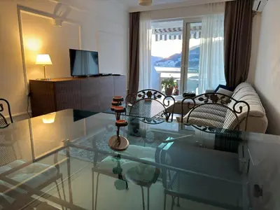 a living room with a glass table and chairs at Front Row Sunset in Rafailovici