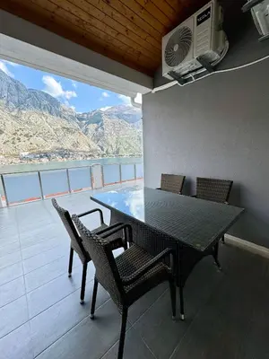 a table and chairs on a balcony with a view at Apartments Seaview Estate Radovic in Kotor