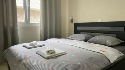 a bed with two folded towels on top of it at Apartments Seaview Estate Radovic in Kotor