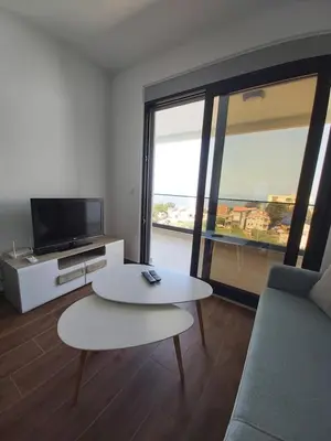 a living room with a couch and a table and a tv at Apartmani Aida in Dobra Voda