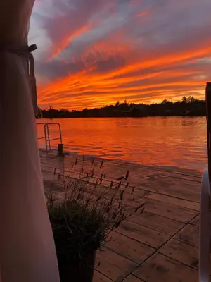 a sunset over the water with a bird on a dock at Sojenica Ivona in Ulcinj