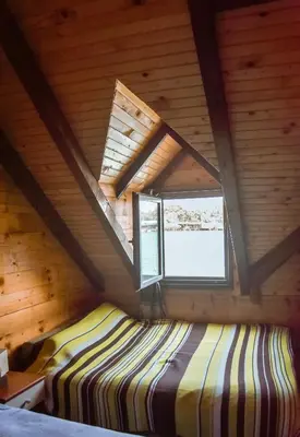 a bedroom in a log cabin with a window at Sojenica Ivona in Ulcinj