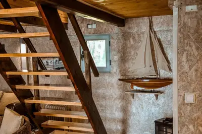 a wooden staircase in a room with a sailboat on the wall at Sojenica Ivona in Ulcinj