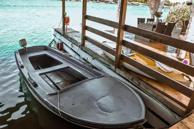 a boat sitting on the water next to a dock at Sojenica Ivona in Ulcinj